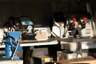 A man is standing in back of a van that is loaded with tools