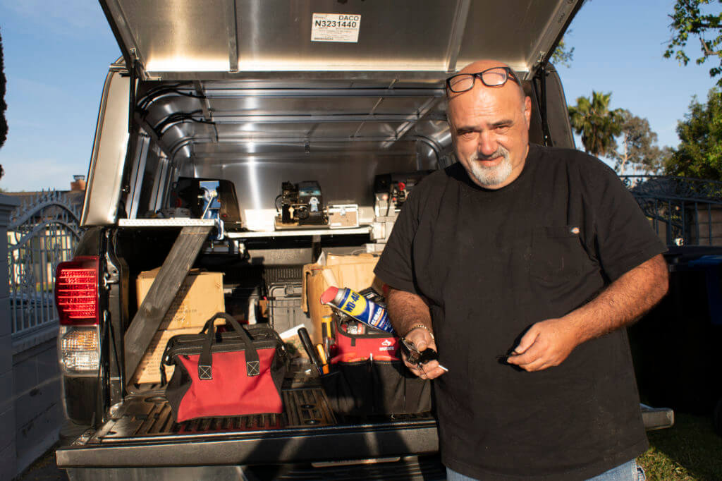 Man standing next to open truck with equipment